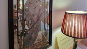 Une œuvre d’art encadrée représentant une femme en robe, une lampe et un panneau indiquant la disponibilité du Wi-Fi.