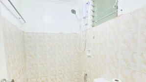 A small bathroom with a toilet, a shower, and a sink. - Glo's Space Boracay Dmall (Boracay Island)