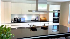 A modern kitchen with a large island, built-in appliances, and a sleek design.