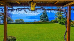 A covered outdoor area with a view of a mountain range and a clear sky.