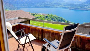 A balcony with a view of a lake and mountains.