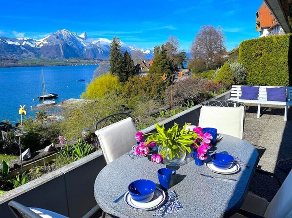 A table set outdoors with a view of a lake and mountains.