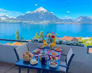 Een ontbijttafel met uitzicht op een berg en meer.