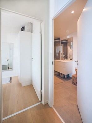 Een moderne badkamer met een grote spiegel, een wastafel en een wasmachine.