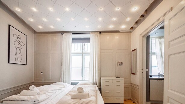 Una camera da letto con un letto grande, un comodino, un armadio e una finestra con tende.