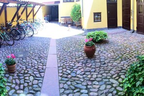 Stroll through the charming courtyard, surrounded by a central pathway and lush greenery.