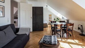 Een modern loft appartement met een eethoek, een bank en een klein tafeltje.