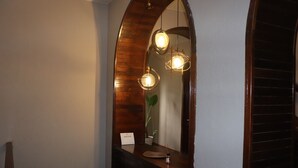 Uma casa de banho com toucador de madeira, espelho e três pendentes.