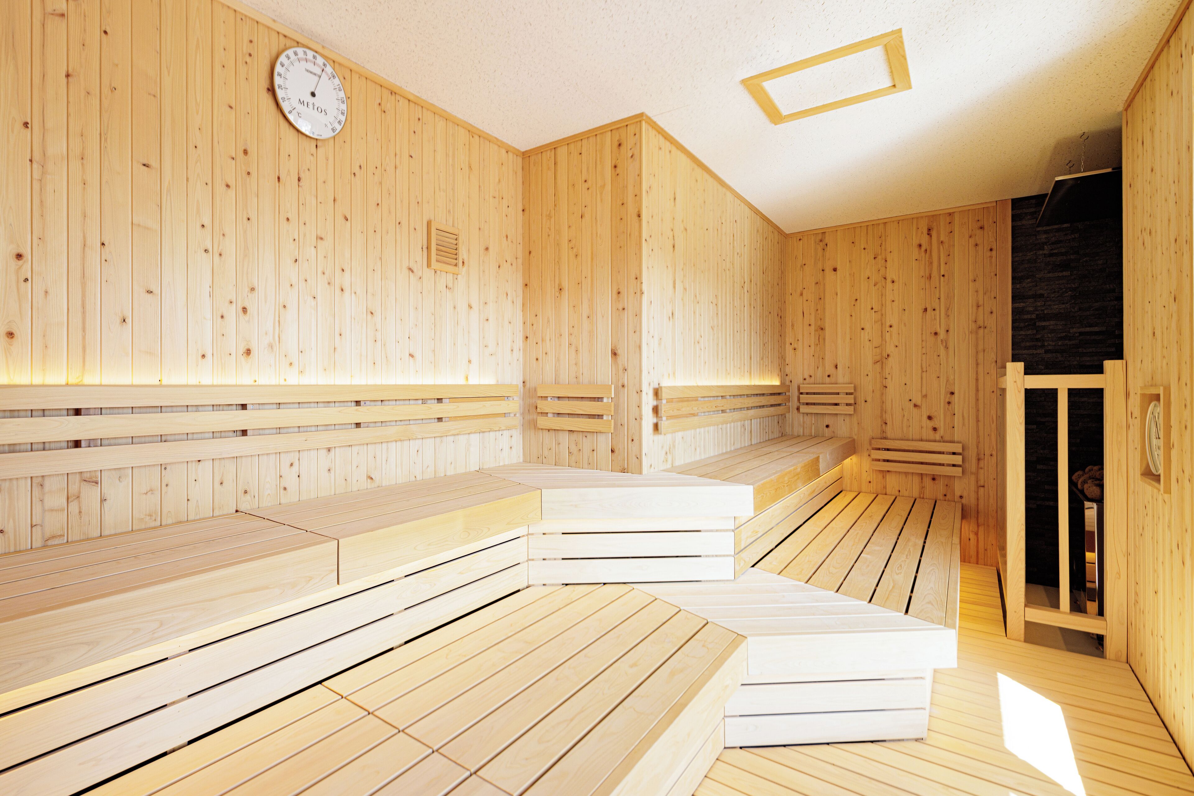 Una sauna de madera con bancos y un reloj en la pared.