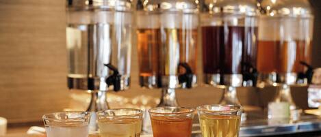 A bar area with shot glasses filled with different beverages and a backdrop with the text "AMANEY LOUCE".