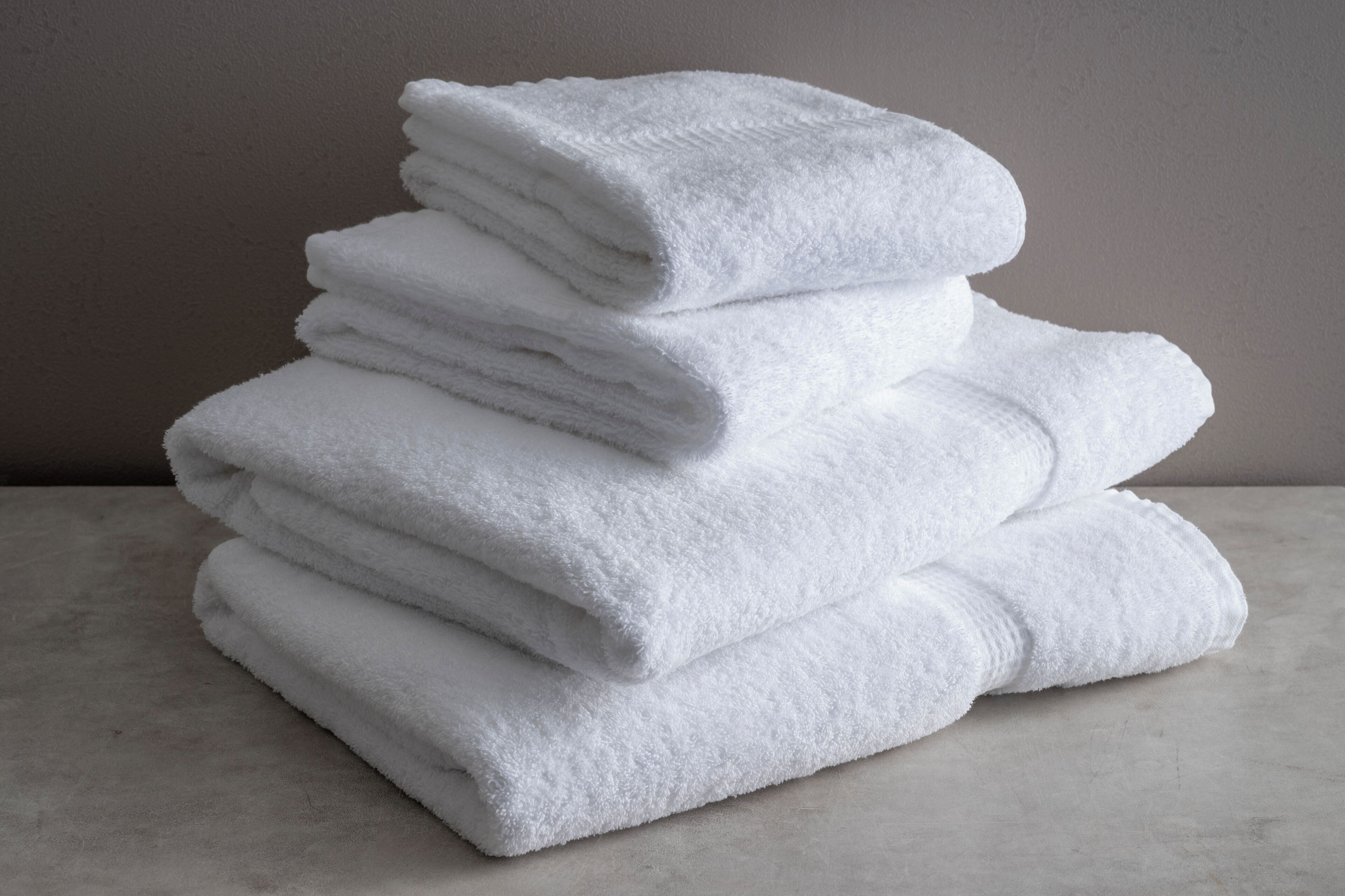 Une pile de serviettes blanches sur une surface en marbre.