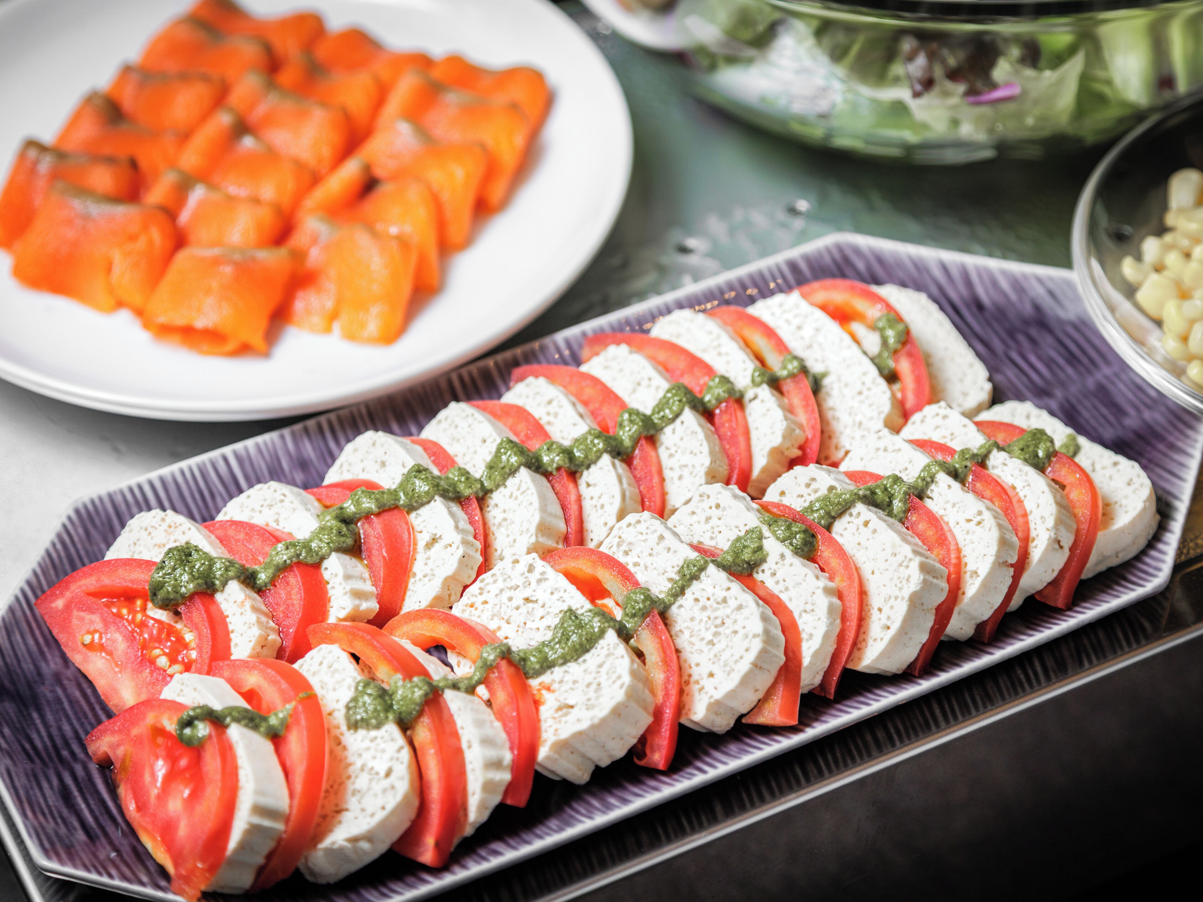 A plate of Caprese salad with tomatoes, mozzarella, and basil.