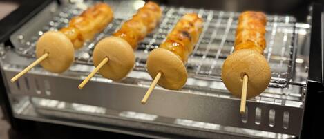 A grill with four skewers of food.