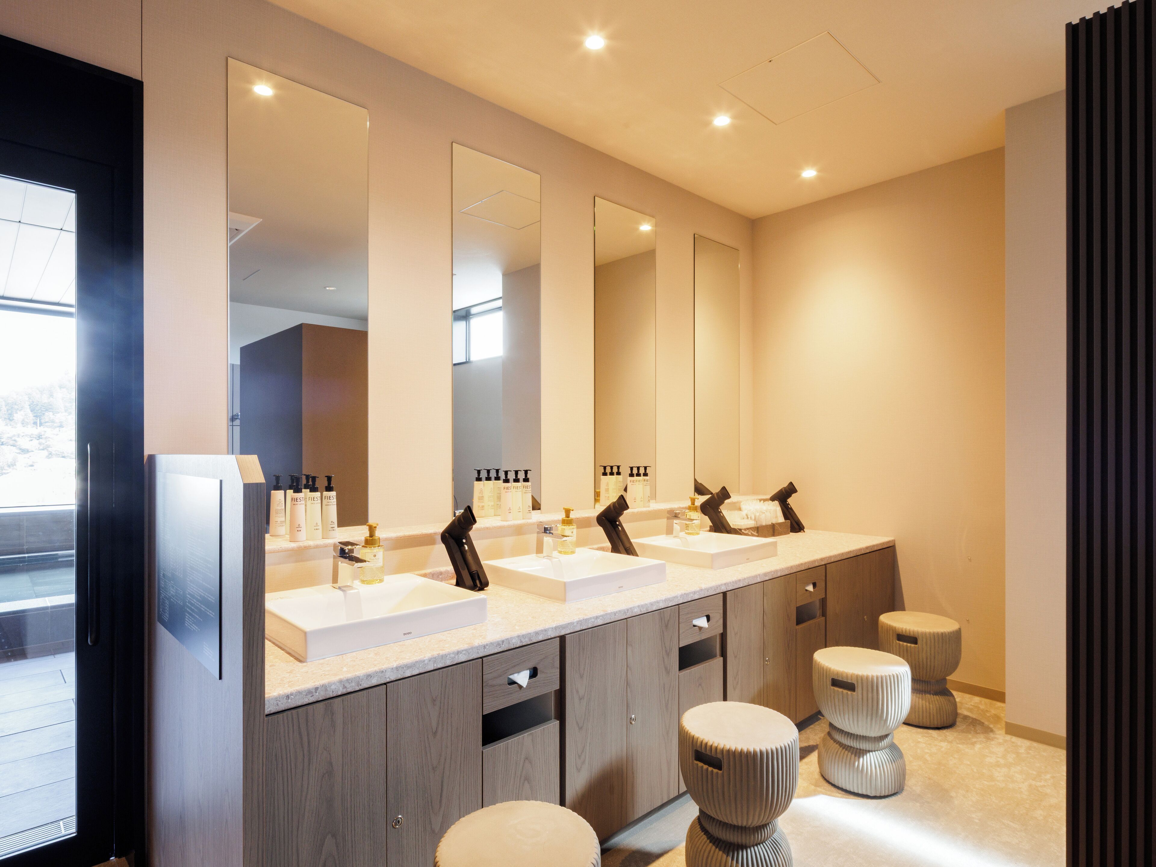 Une salle de bain moderne avec deux lavabos, de grands miroirs et des meubles en bois.