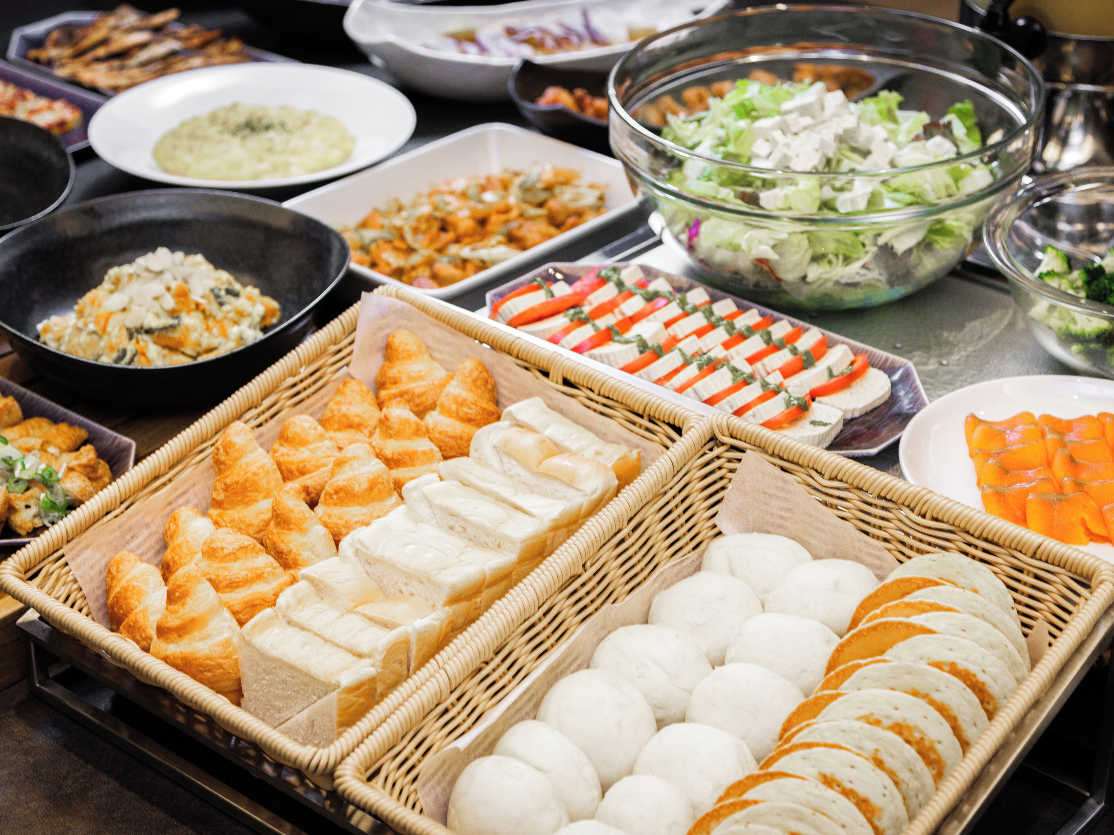 A buffet with various food items including bread, salads, and other dishes.