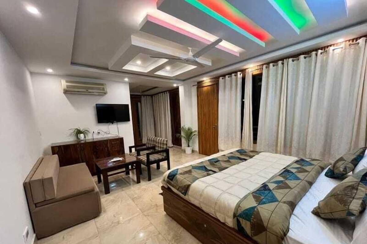 Un dormitorio moderno con una cama grande, un escritorio y un televisor.