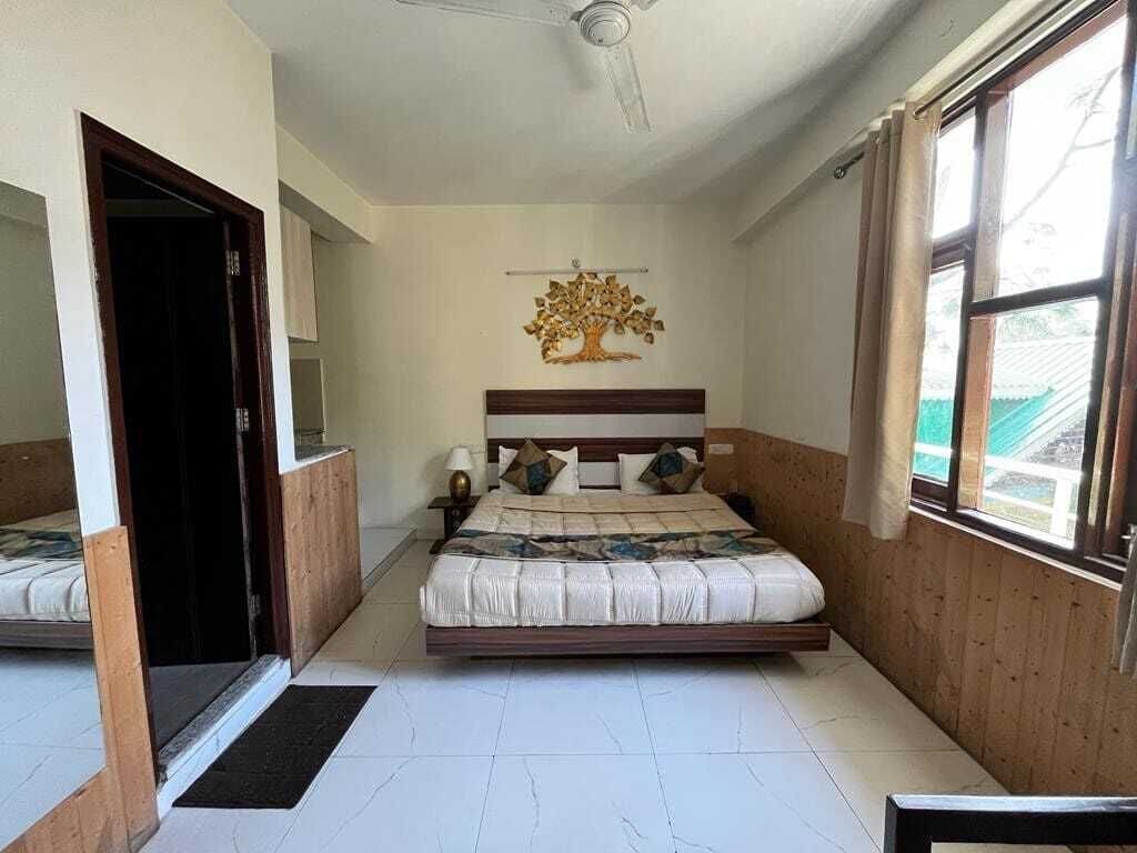 A bedroom with a bed, a ceiling fan, a window, and a door.