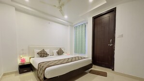 A bedroom with a bed, nightstand, and a ceiling fan. - Satkar Retreat (Udaipur)