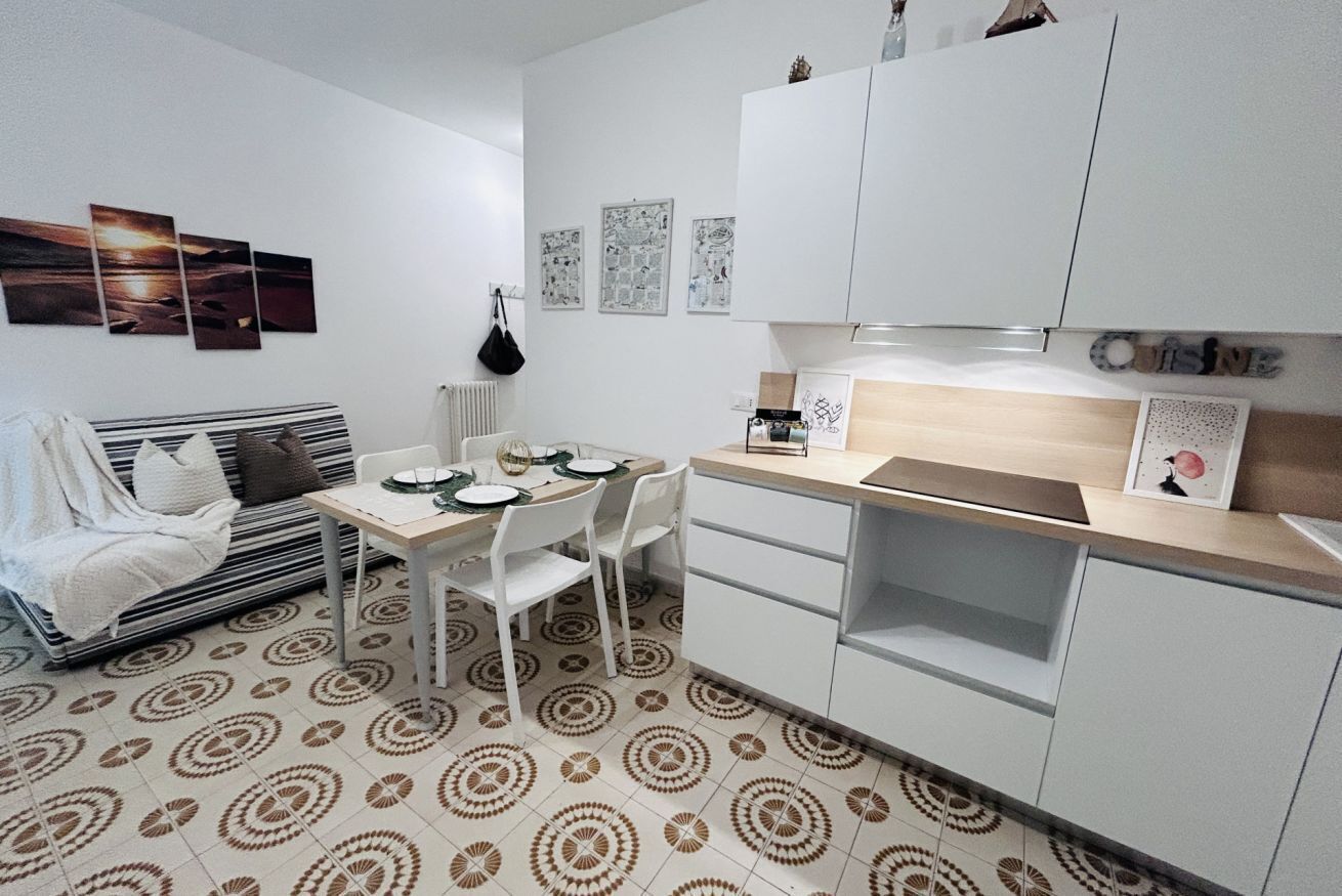 A compact living space with a dining area, kitchenette, and a sofa.