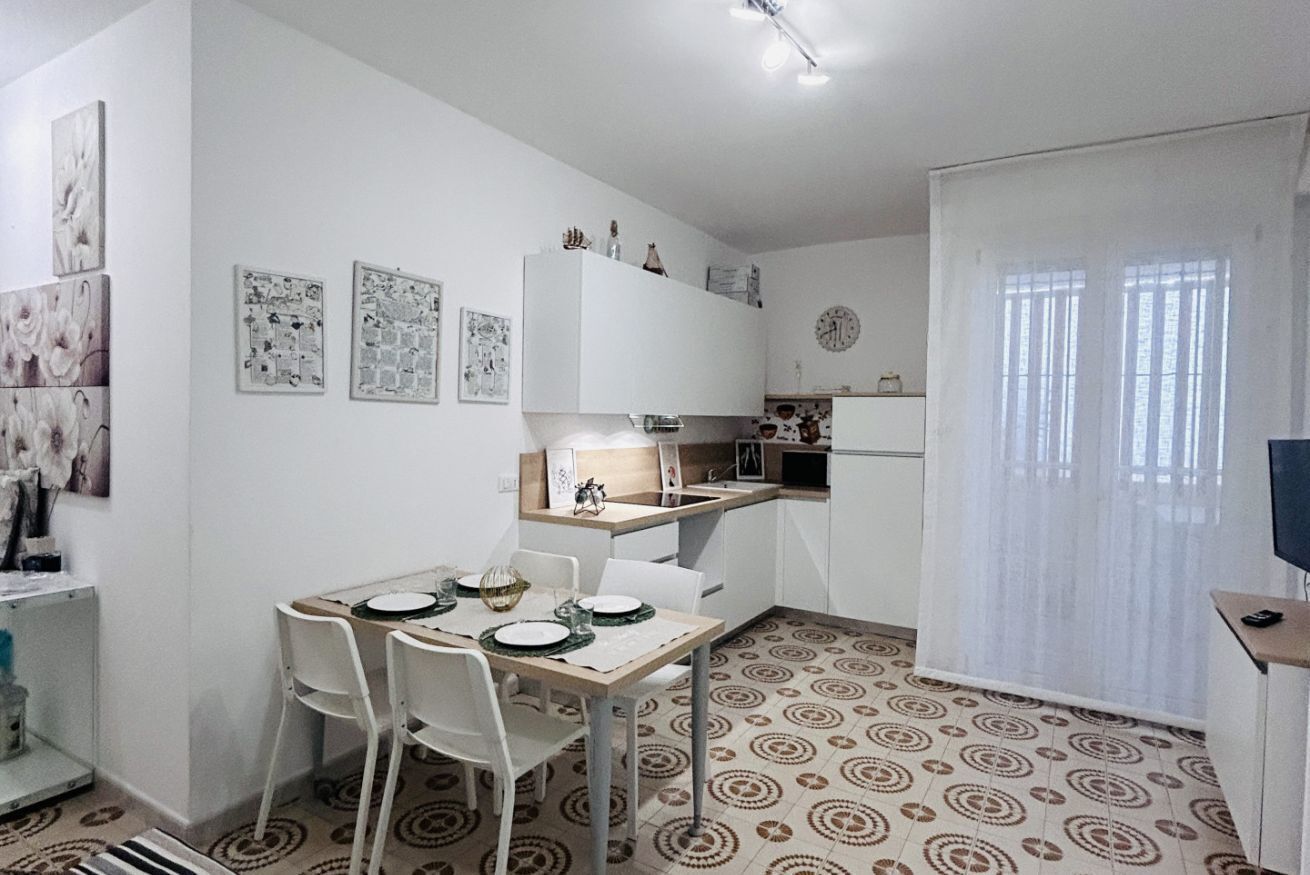 Un espace de vie compact comprenant un coin repas, un coin cuisine et une petite cuisine.