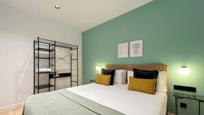 Ein Schlafzimmer mit einem Bett, einem an der Wand befestigten Regal, zwei Wandleuchten und einer Deckenlampe.