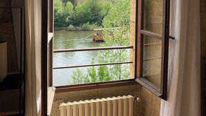 A room with a large window overlooking a river and greenery.