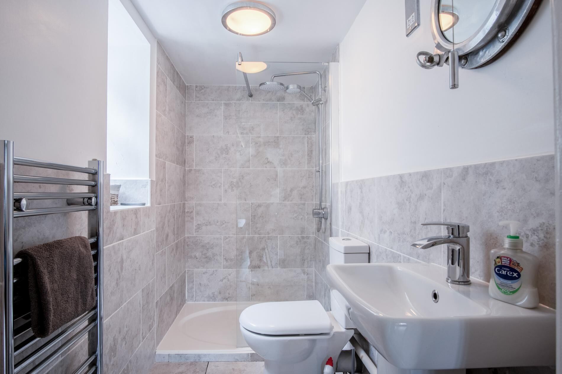 Une salle de bain moderne équipée d’une douche, de toilettes et d’un lavabo.