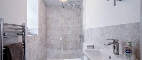 Une salle de bain moderne équipée d’une douche, de toilettes et d’un lavabo.