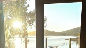 A view from a room with a large window overlooking a wooden deck and a body of water. - Lakeside Abode at Taylor Bay | Lake Eildon (Taylor Bay)