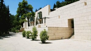 A modern building with a clean, geometric design, featuring a prominent staircase and a series of small windows.