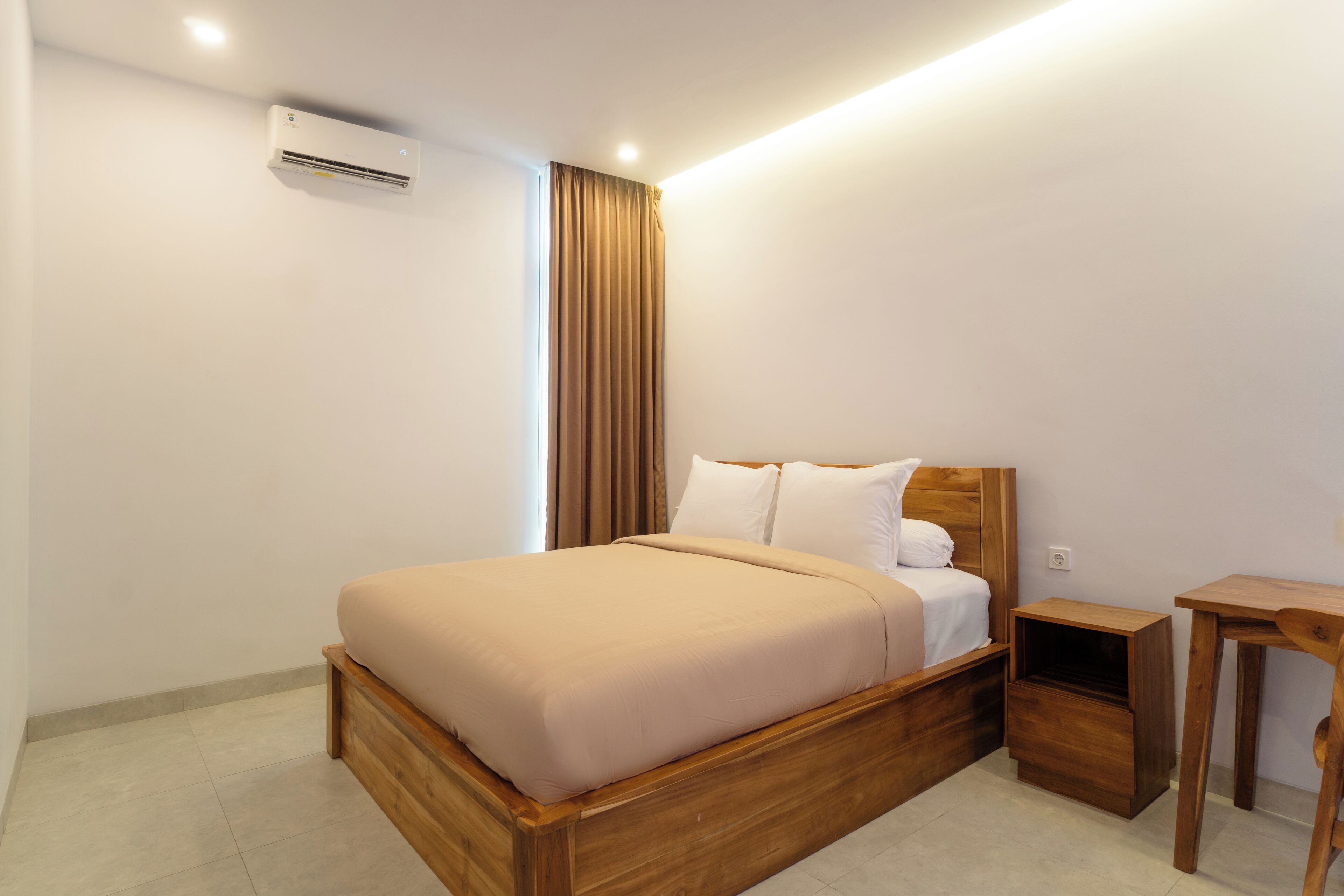 Un dormitorio ordenado con una cama de madera, una mesita de noche y un equipo de aire acondicionado en la pared.