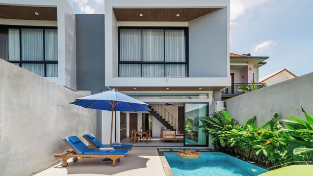 A modern two-story building with a swimming pool, lounge chairs, and a dining area. - Sanur Bali Villas by Premier Hospitality Asia (Denpasar)