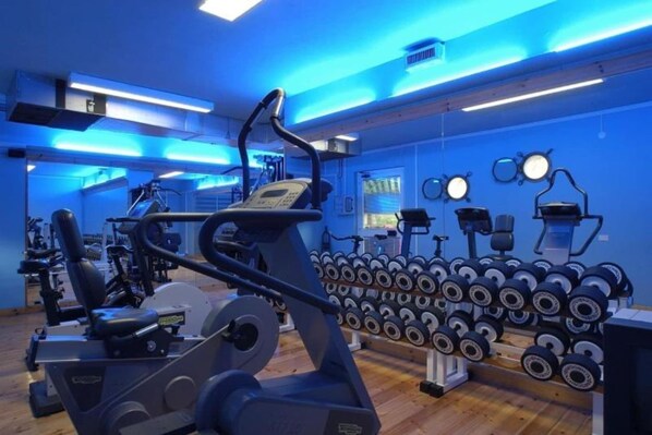 A gym with cardio machines, dumbbells, and exercise equipment.