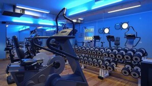Une salle de sport équipée de machines de cardio, d’haltères et d’appareils d’exercice.