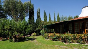 A garden with a white building, stone pathway, and various plants. - Mobilheim auf dem Hügel mit Pool (VILLANOVA D'ALBENGA)
