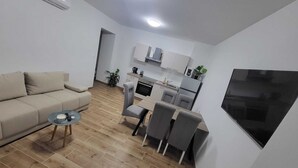 Ein modernes Wohnzimmer mit einer Couch, einem Couchtisch und einem Essbereich mit Stühlen.