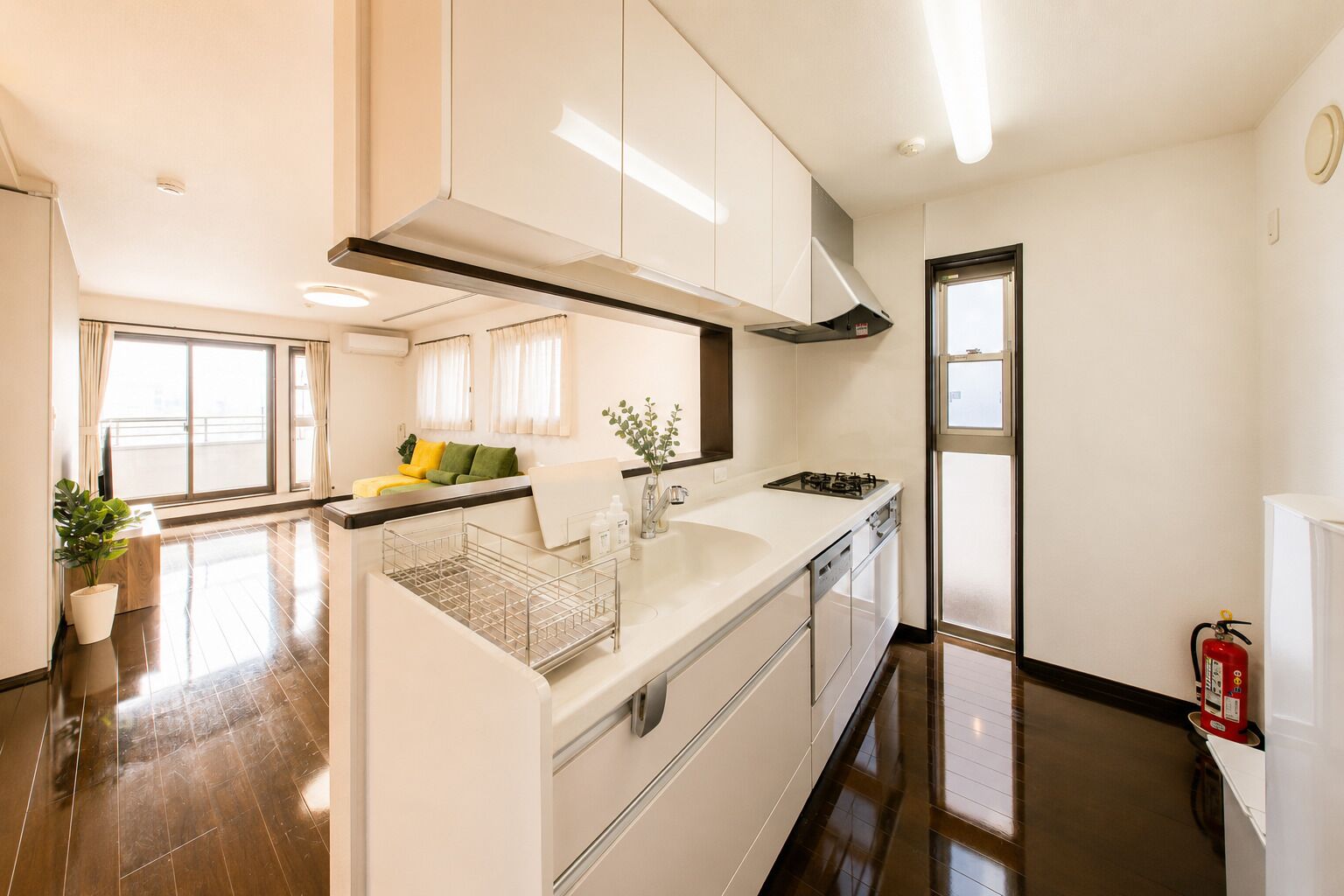A modern kitchen with white cabinetry, a stainless steel range hood, and a gas stove.