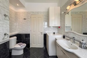 Un bagno moderno con il water, lavandino e specchio.
