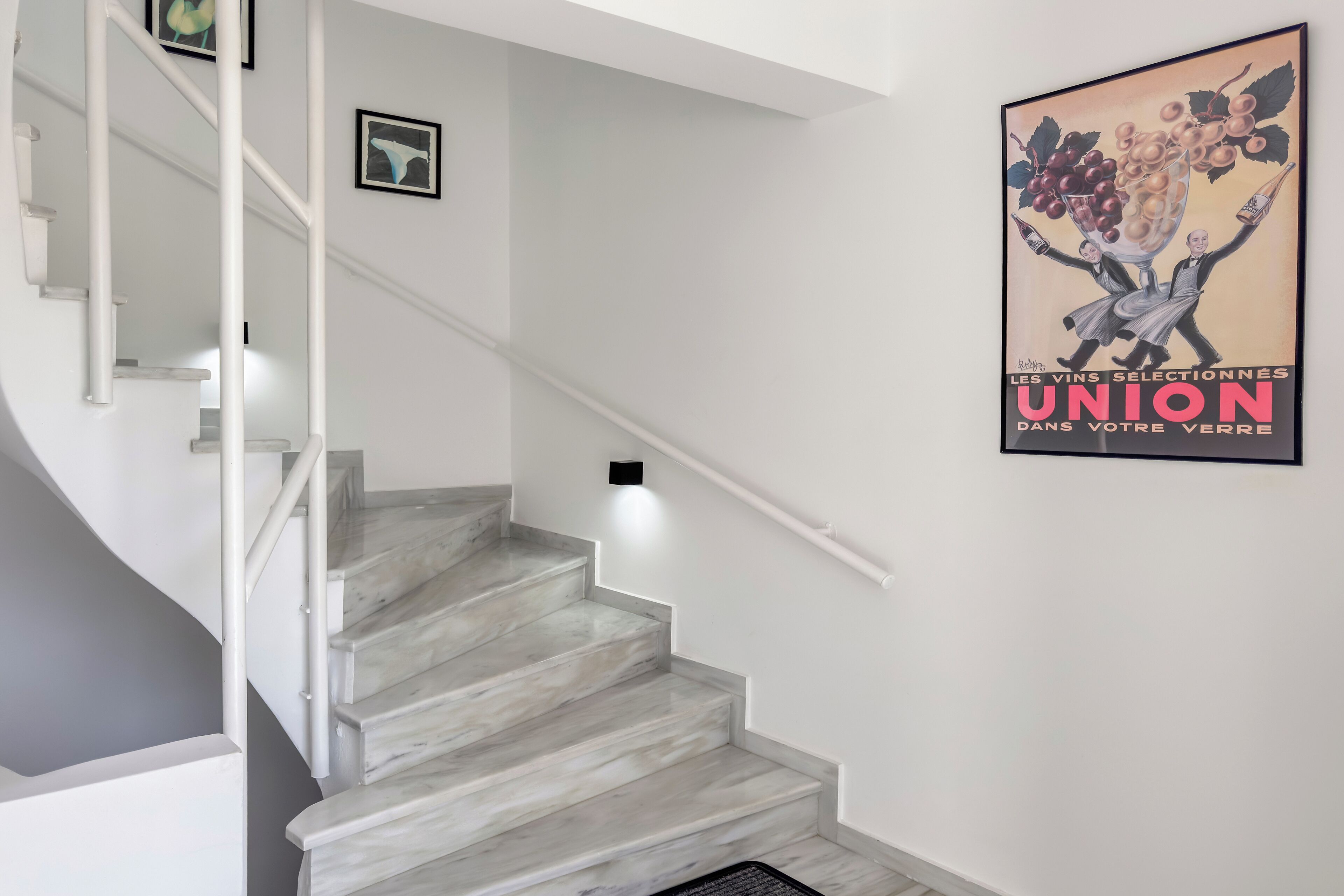 A staircase with white railings and a poster on the wall.