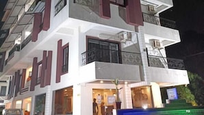 A multi-story hotel with a modern design, featuring balconies and a ground-level entrance. - Rihan Goa Holiday Homes (Calangute)