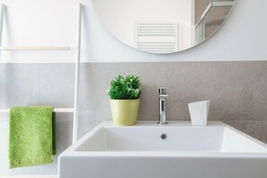 A bathroom with a white sink, a green towel, a potted plant, and a mirror. - Cozy JOIVY Suite 3 with parking (Como)