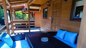 A wooden cabin with a bed, a bench, and a window. - Cottage in Dziwnow Near the Beach (Dziwnów)