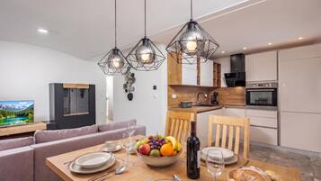 A modern kitchen with a dining area, wooden cabinets, and a built-in oven.
