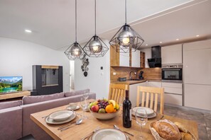 Eine moderne Küche mit Essbereich, Holzschränken und einem eingebauten Backofen.