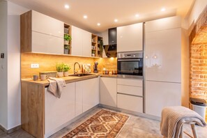 Eine moderne Küche mit Holzelementen, integrierten Geräten und einem gemusterten Teppich.