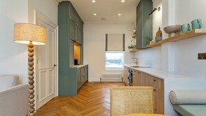 Een moderne keuken met een ingebouwde kookplaat, een raam en een houten eettafel.