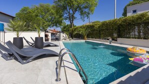 A swimming pool with lounge chairs and a small inflatable float. - Dolce Vita Apartment 3 with Heated Pool near Poreč (Mugeba)