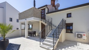 A modern residential building with a staircase, outdoor seating area, and a satellite dish. - Dolce Vita Apartment 3 with Heated Pool near Poreč (Mugeba)