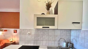 A modern kitchen with a built-in microwave, a stainless steel sink, and a sleek countertop. - Apartment Zeleni Raj 1 (Crikvenica)