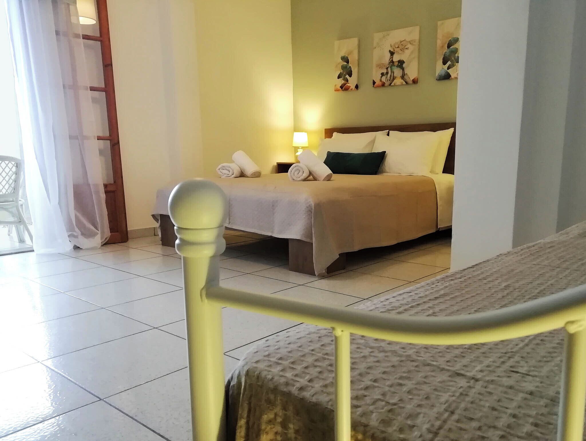 Une chambre d’hôtel avec un lit, une table de chevet, une lampe et des œuvres d’art accrochées au mur.